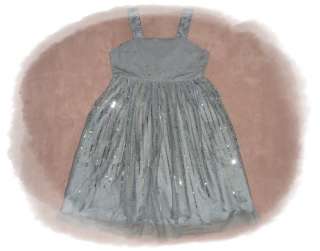 Das Kleid hat breite Träger und einen dekorativen Ausschnitt. Der 