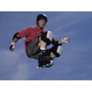  Teenage Boy Jumping in Mid Air Wearing Inline Skates 
